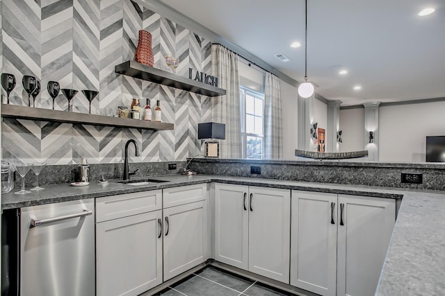 kitchen featuring sink, dark tile patterned floors, white cabinetry, and hanging light fixtures