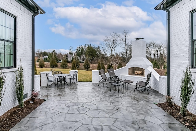 view of patio with exterior fireplace