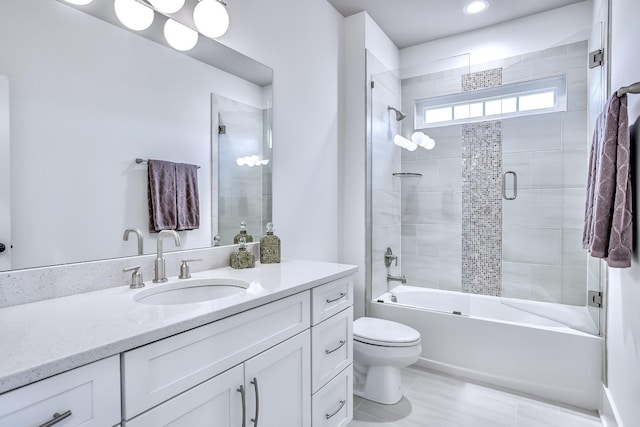 full bathroom with enclosed tub / shower combo, vanity, and toilet