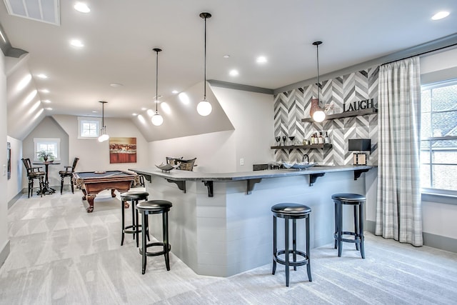 kitchen with vaulted ceiling, pendant lighting, billiards, light colored carpet, and a breakfast bar area