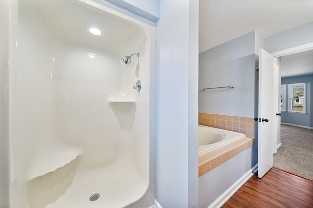 bathroom with independent shower and bath and hardwood / wood-style flooring