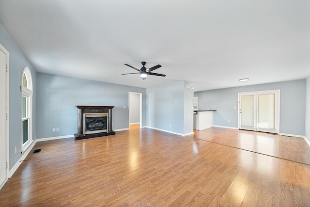 unfurnished living room featuring ceiling fan and light hardwood / wood-style flooring