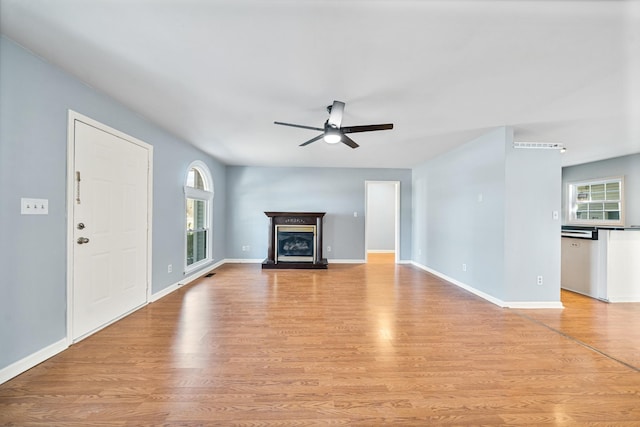 unfurnished living room featuring ceiling fan and light hardwood / wood-style floors