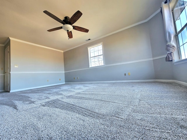 empty room featuring ceiling fan, crown molding, and carpet