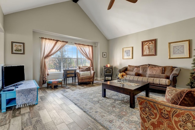 living room featuring wood-type flooring, high vaulted ceiling, ceiling fan, and a wood stove