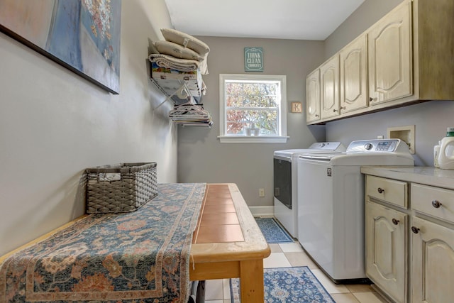 clothes washing area featuring light tile patterned flooring, separate washer and dryer, and cabinets