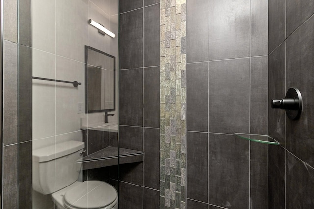 bathroom with toilet and a tile shower