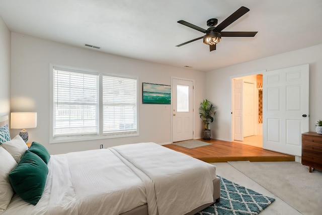 bedroom featuring ceiling fan, connected bathroom, and multiple windows