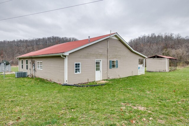 view of home's exterior with central air condition unit and a lawn