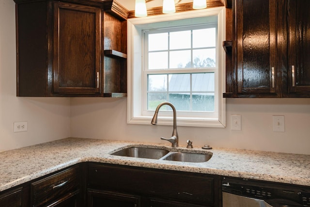 kitchen with sink, dishwasher, dark brown cabinets, and light stone countertops