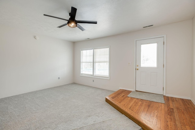 carpeted entrance foyer with ceiling fan