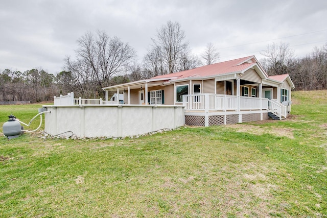 rear view of property featuring a porch and a yard