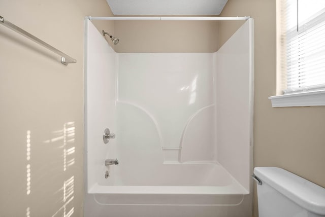 bathroom with toilet, a textured ceiling, and bathtub / shower combination