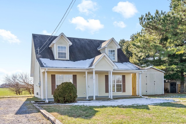 cape cod house with covered porch and a front yard