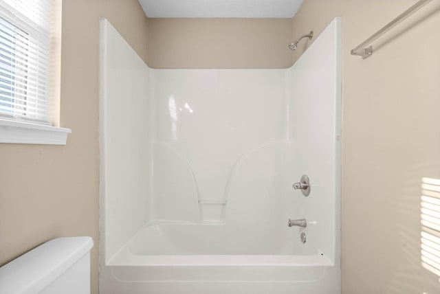 bathroom featuring toilet and shower / bathing tub combination