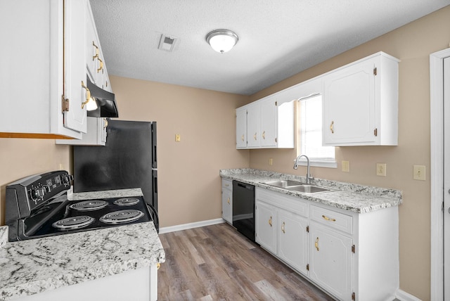 kitchen featuring sink, white cabinets, a textured ceiling, light hardwood / wood-style floors, and black appliances