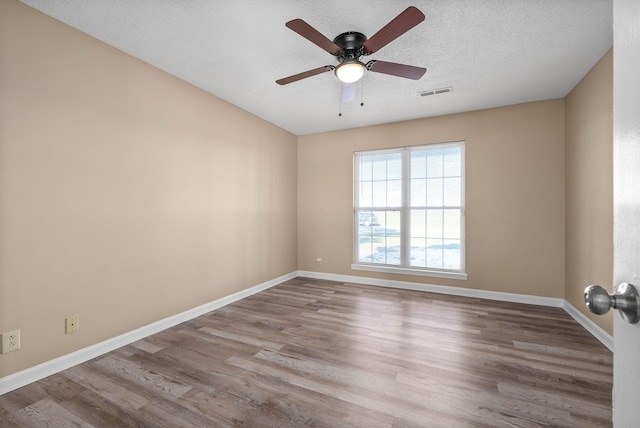 spare room with wood-type flooring, a textured ceiling, and ceiling fan