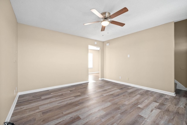 spare room with a textured ceiling, ceiling fan, and hardwood / wood-style flooring