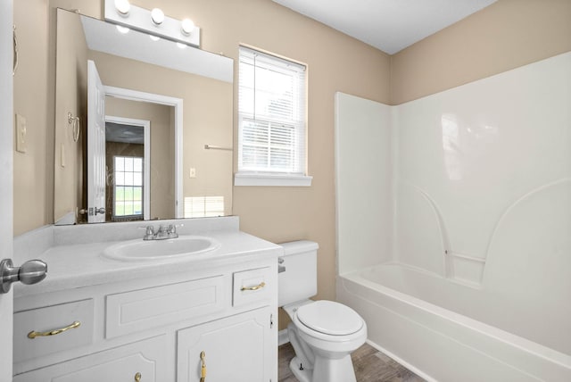 full bathroom featuring tub / shower combination, hardwood / wood-style floors, vanity, and toilet