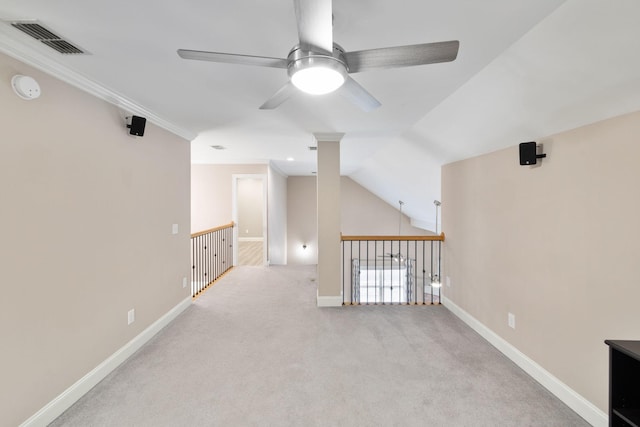 interior space featuring light carpet, ceiling fan, vaulted ceiling, and ornamental molding