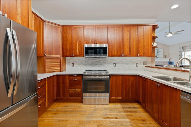 kitchen with appliances with stainless steel finishes, ceiling fan, sink, and tasteful backsplash