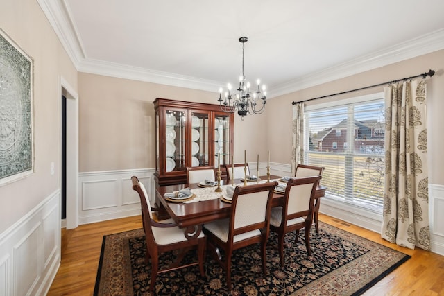 dining room with a chandelier, hardwood / wood-style flooring, and crown molding