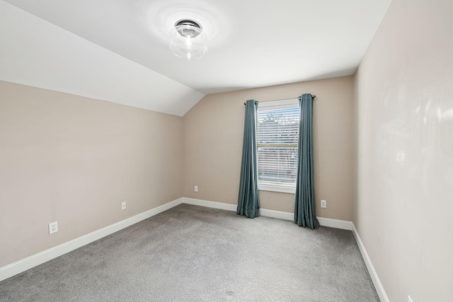 additional living space featuring light colored carpet and vaulted ceiling