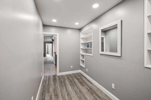 hall with dark hardwood / wood-style flooring and built in shelves