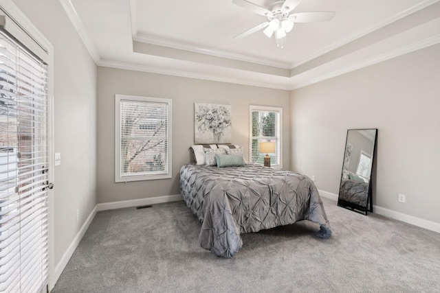 bedroom featuring ceiling fan, crown molding, light carpet, and a tray ceiling