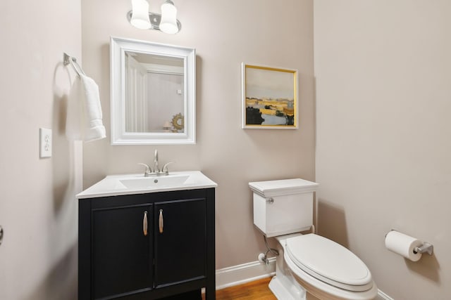 bathroom with toilet, wood-type flooring, and vanity