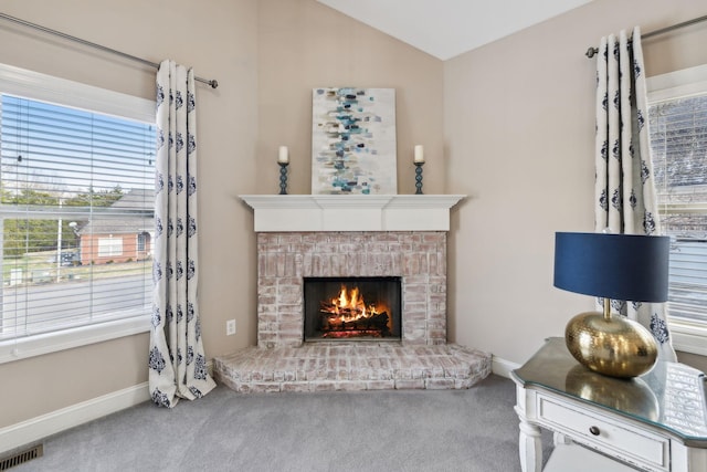 carpeted living room with vaulted ceiling and a fireplace