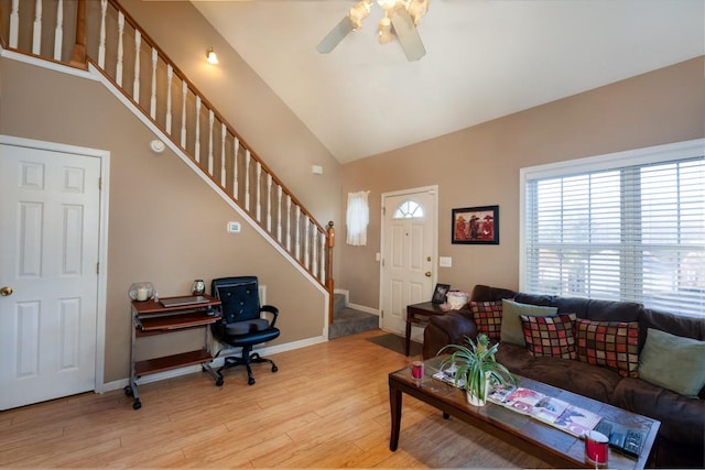 living room featuring ceiling fan, high vaulted ceiling, and light wood-type flooring