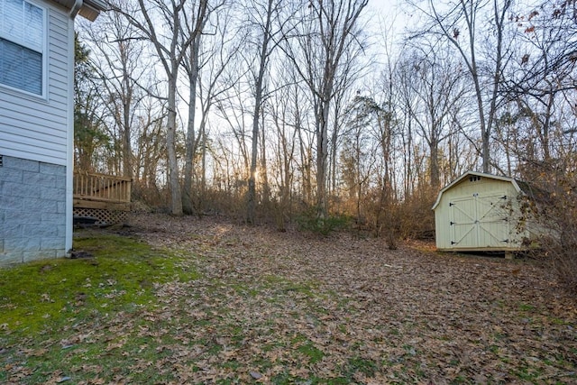 view of yard featuring a shed and a wooden deck