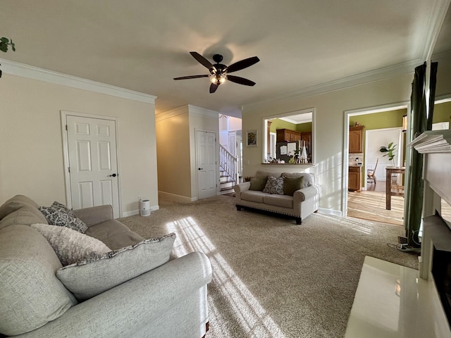 carpeted living room with ceiling fan and ornamental molding