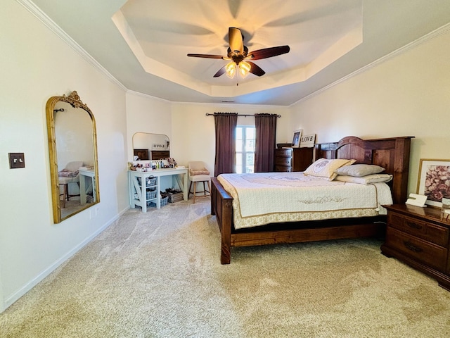 carpeted bedroom with ceiling fan and a tray ceiling