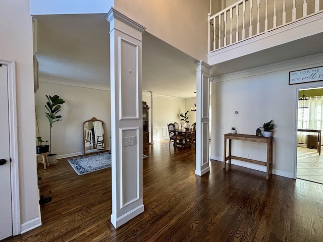 foyer with ornamental molding, dark hardwood / wood-style flooring, and decorative columns