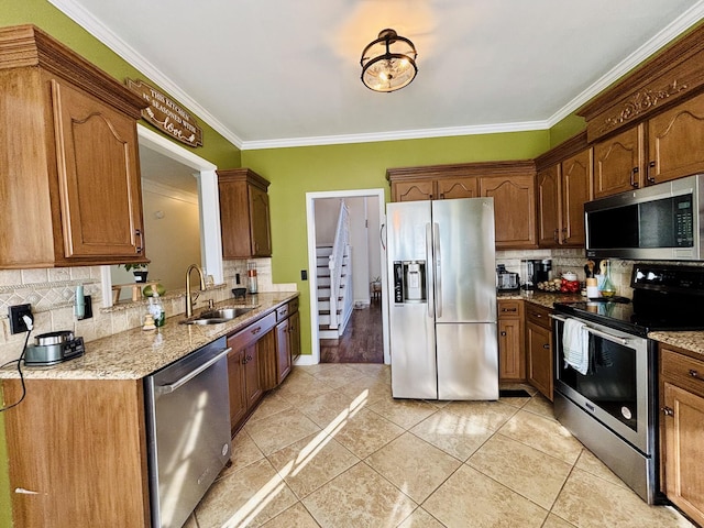 kitchen with appliances with stainless steel finishes, decorative backsplash, crown molding, and sink