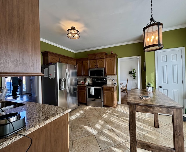 kitchen with appliances with stainless steel finishes, crown molding, light tile patterned floors, stone countertops, and decorative light fixtures