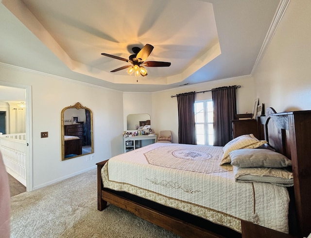 carpeted bedroom with ceiling fan, a tray ceiling, and ornamental molding