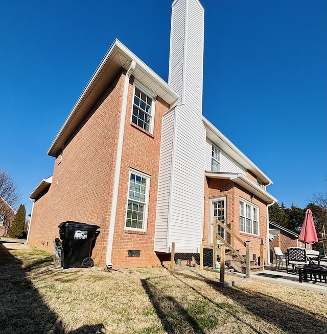 back of property featuring a lawn and a patio