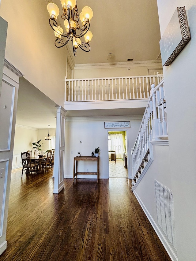 foyer featuring crown molding, a chandelier, and dark hardwood / wood-style floors