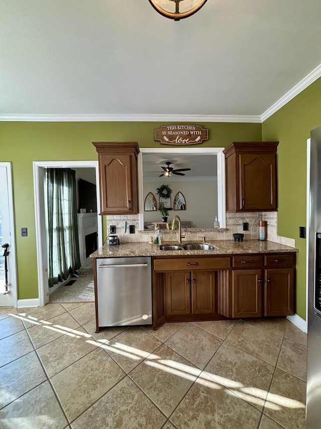 kitchen with stainless steel appliances, ornamental molding, ceiling fan, sink, and tasteful backsplash