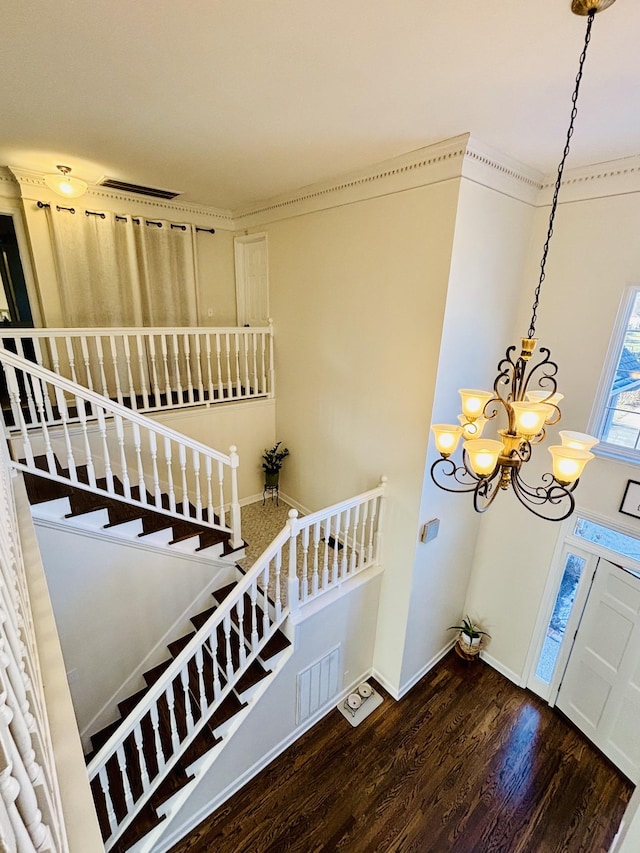 entryway featuring a notable chandelier, crown molding, and hardwood / wood-style flooring