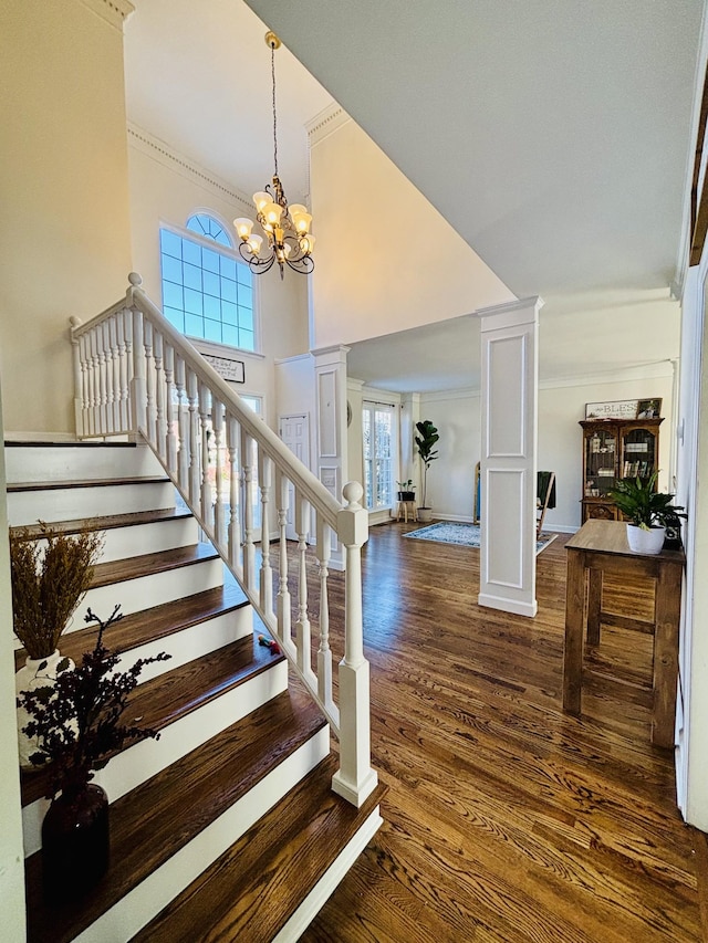 staircase with a notable chandelier, ornamental molding, and hardwood / wood-style flooring