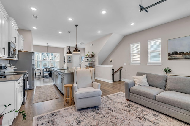 living room featuring sink and light hardwood / wood-style flooring