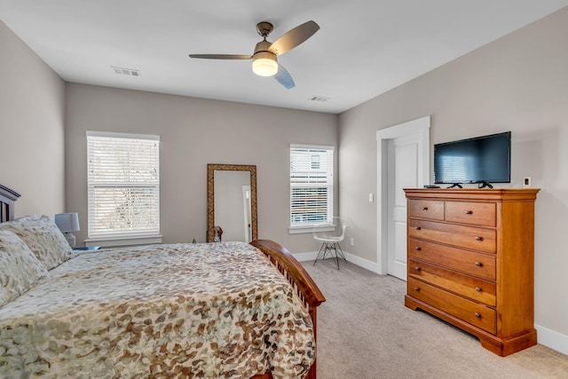 carpeted bedroom with ceiling fan and multiple windows