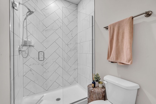 bathroom featuring toilet and a shower with shower door