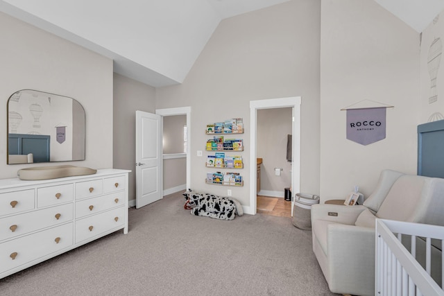 carpeted bedroom with a crib and high vaulted ceiling