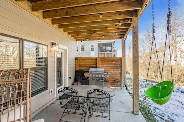 snow covered patio featuring a grill