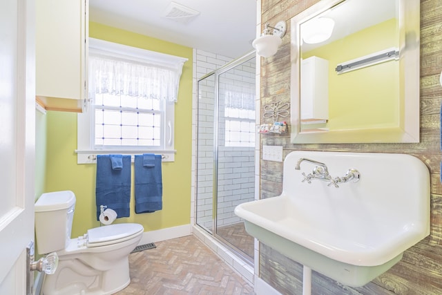 bathroom with sink, toilet, and an enclosed shower